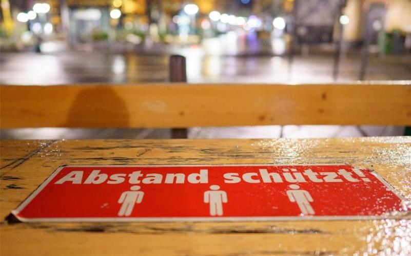 „Abstand schützt“ steht auf Tischen im Außenbereich eines Lokals auf dem Frankfurter Römerberg. Foto: Frank Rumpenhorst/dpa