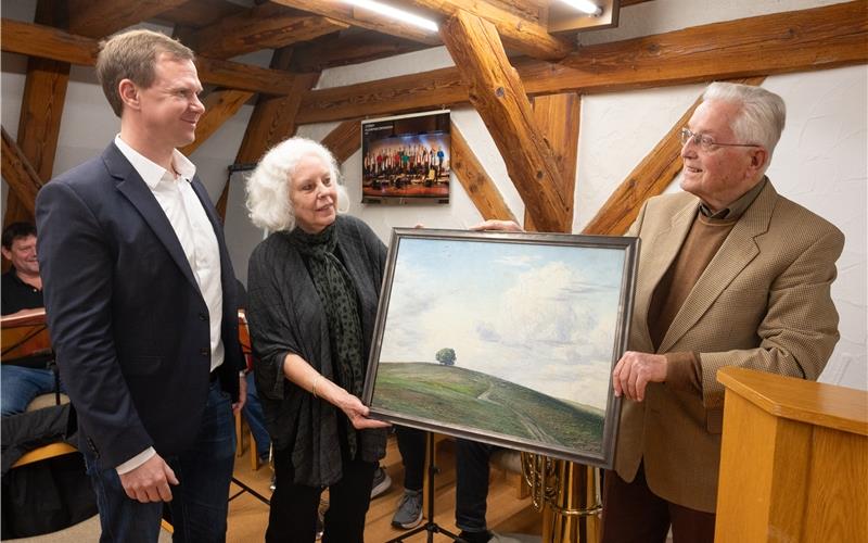 Adalbert (rechts) und Monika Kühnle schenken der Gemeinde das Bild Schillerlinde. Bürgermeister Dennis Mews nimmt es erfreut entgegen. GB-Foto: Schmidt