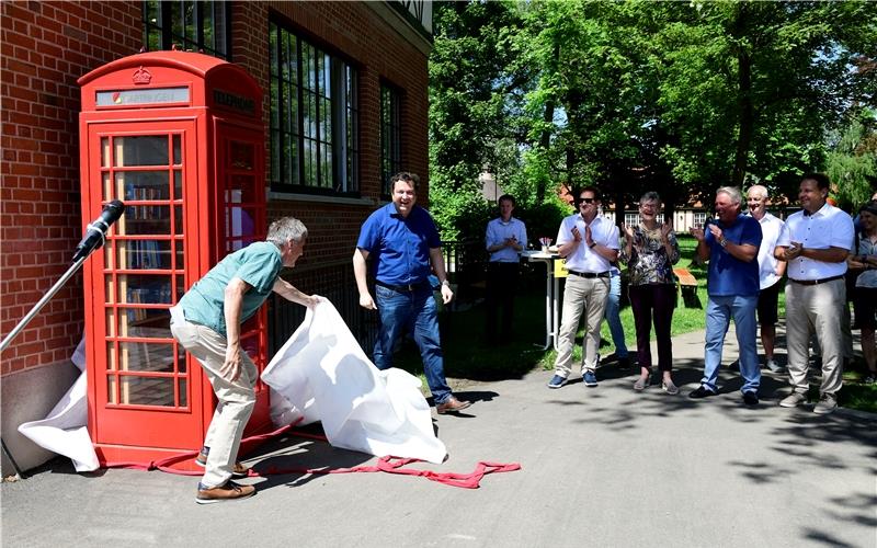 Als Überraschung enthüllte der Schultes Thomas Riesch (Zweiter von links) eine leuchtend rote, englische Telefonzelle, die – als Büchertelefonzelle – es ermöglicht, Bücher 24 Stunden am Tag auszuleihen. GB-Foto: Holom
