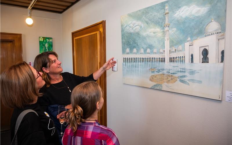 Annette Trenz (mit erhobenem Arm) vor ihrem Bild „Moschee“, das in der Ausstellung im Rathaus zu sehen ist. GB-Foto: Schmidt