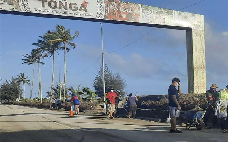 Aufräumarbeiten auf einer Straße in Nuku'alofa. Sechs Tage nach der Eruption eines Untersee-Vulkans vor Tonga ist der Flughafen des Südsee-Archipels wieder funktionsfähig. Foto: Marian Kupu/Broadcom Broadcasting/AP/dpa