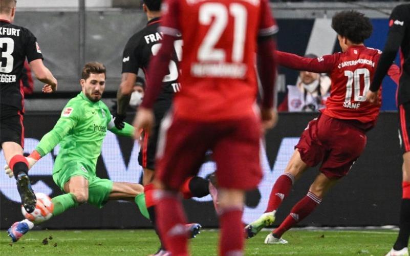 Bayerns Leroy Sané (r) erzielt das Tor zum 1:0 gegen Frankfurts Torwart Kevin Trapp. Foto: Arne Dedert/dpa