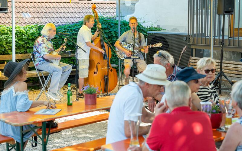 Bei bis zu 34 Grad Celsius waren Schatten und kühle Getränke auch beim Konzert des Trios „Backporch“ im Rahmen des Entringer Jubiläumsfests unabdingbar. GB-Foto: Vecsey