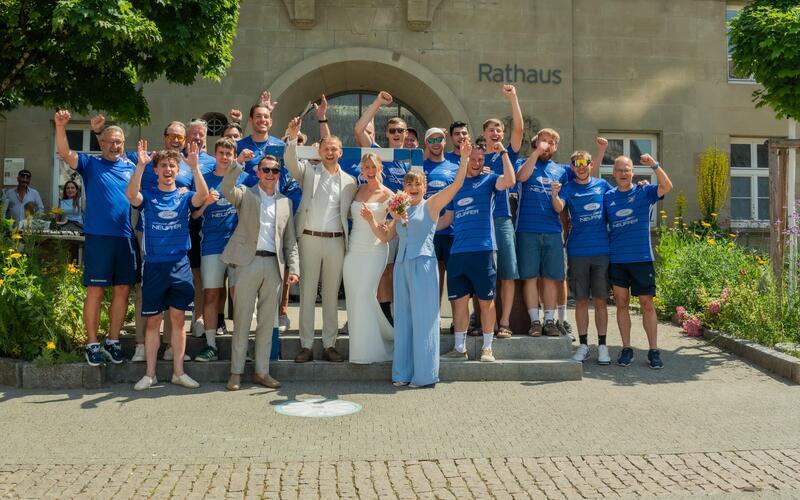 Brautpaar wandelt unter einem blau-weißen Tornetz