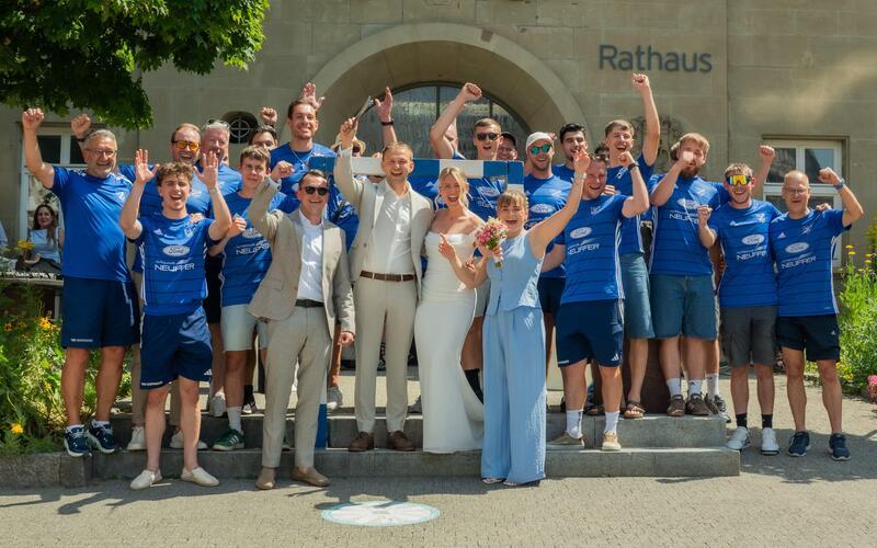 Brautpaar wandelt unter einem blau-weißen Tornetz