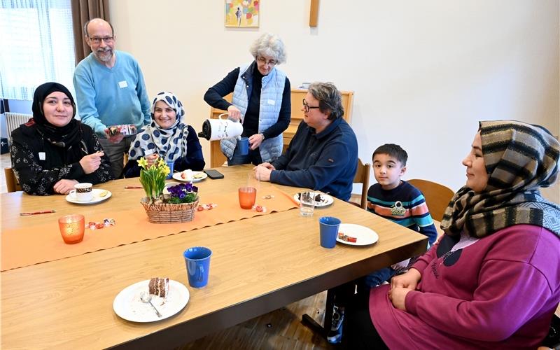 Café International in Hildrizhausen: Die Ehrenamtlichen Gerhard und Doris Bahr (beide stehend) und Pfarrer Andreas Roß mit den Gästen im evangelischen Gemeindehaus.GB-Foto: Holom