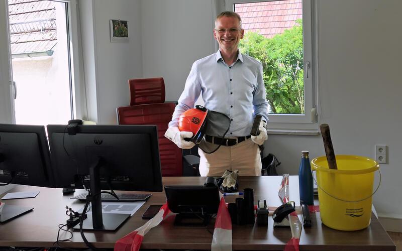 Daniel Rudolph musste sich an seinem ersten Arbeitstag durch eine Papierwand im Steinmauer-Design kämpfen – dazu stellten ihm die Rathausmitarbeiter das entsprechende Werkzeug zur Verfügung.GB-Foto: Gokeler