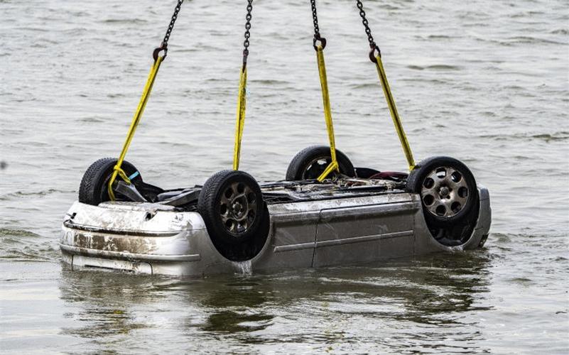 Der Pkw wird in Wesel aus dem Wasser gezogen. Der Wagen mit fünf Insassen war in den Rhein gestürzt, zwei Menschen überlebten. Foto: Arnulf Stoffel/dpa