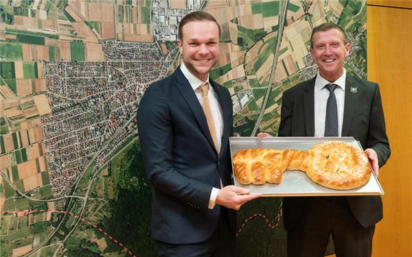 Der neue Bürgermeister Simon Speiser (links) erhielt von seinem Vorgänger Ingolf Welte den symbolischen Rathausschlüssel als Hefegebäck überreicht. GB-Foto: Vecsey