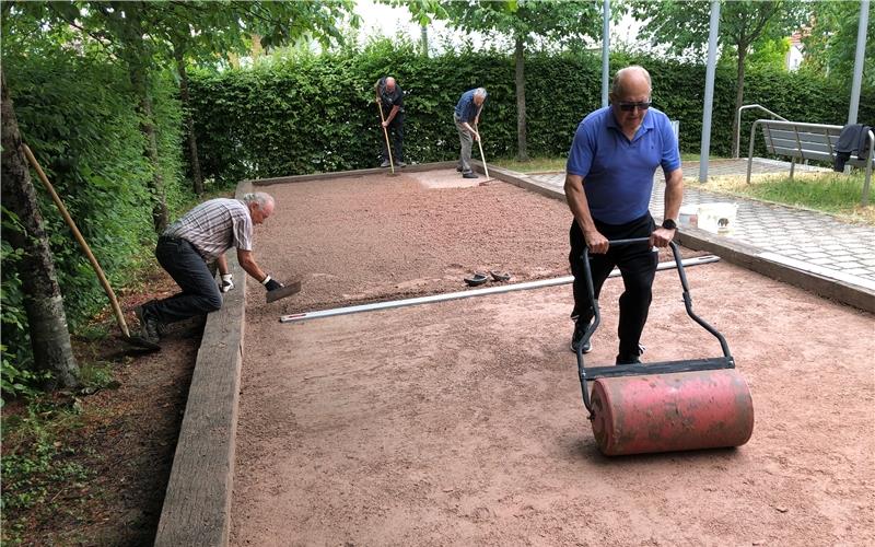 Die Boule-Freunde bringen die Bahn in Schuss, damit die Besucher am heutigen Jubiläumstag ihre Freude daran haben können: Jürgen Brecht an Walze, am Rechen Wolfdieter Riehm und Herbert Heyenbruch und Willi Marquardt (links im Bild). GB-Foto: Lübbert