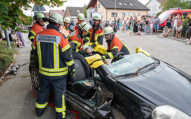 Die Feuerwehrleute umringen das demolierte Auto, um den eingeklemmten Unfallfahrer zu befreien. Gespannt verfolgen die Zuschauer diese Rettungsübung.GB-Foto: Vecsey