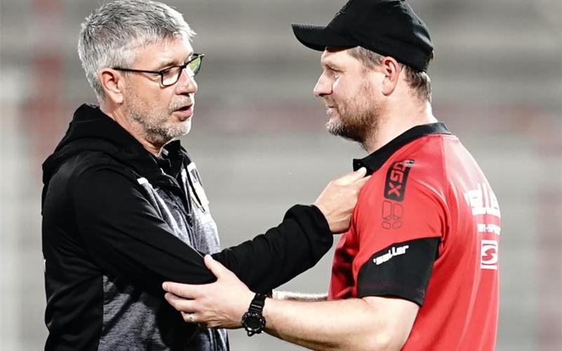 Die Trainer Urs Fischer und Steffen Baumgart (r) unterhalten sich nach einem Spiel. Foto: Kay Nietfeld/dpa