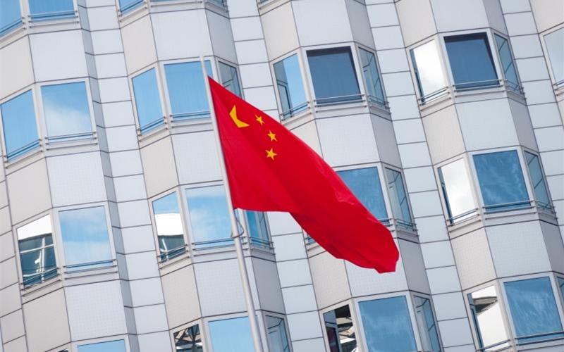 Die chinesische Fahne weht am Botschaftsgebäude der Volksrepublik China in Berlin. Die Botschaft sieht wegen der Ausbreitung des Coronavirus mehr Fälle von Anfeindungen gegen chinesische Bürger in Deutschland. Foto: Alex Ehlers/zb/dpa