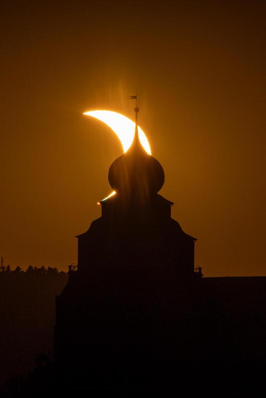 Die partielle verfinsterte Sonne hinter der Stiftskirche. Von Jean-Marie Will au...