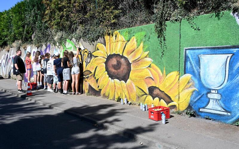 Die trostlose sanierungsbedürftige Betonwand kriegt durch das Graffiti-Projekt vorübergehend einen frischen Anstrich. GB-Foto: Holom