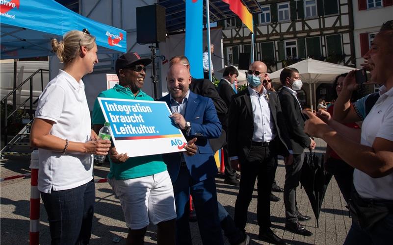 Dr. Alice Weidel und Markus Frohnmaier umrahmen einen AfD-Anhänger GB-Foto: Vecsey