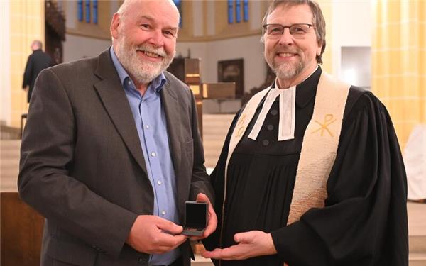 Eberhard Wörner (links) wird von Interimsdekan Thomas Cornelius mit der Johannes-Brenz-Medaille in Bronze ausgezeichnet. GB-Foto: Reichert