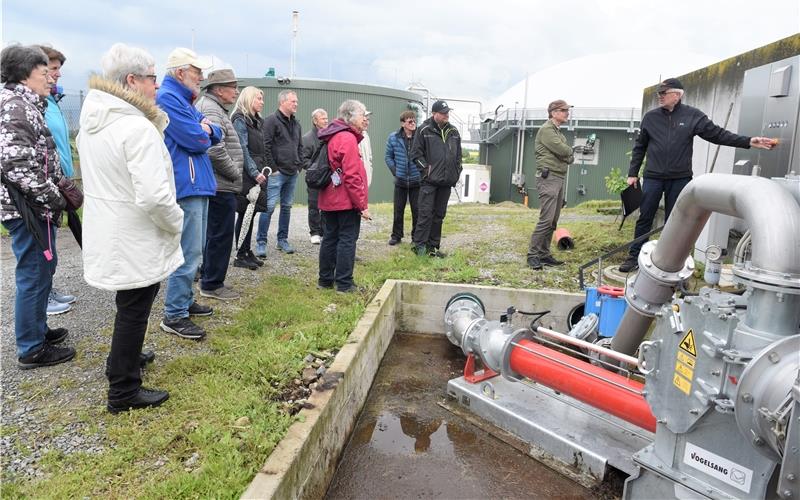 Edgar Leckel (rechts) erläutert bei einer von der Volkshochschule organisierten Führung die Biogasanlage auf dem Wolfer’schen Hof in Oberjettingen. Im Hintergrund links der Fermenter und rechts mit der weißen Kuppel das Gärrestelager. GB-Foto: Reichert