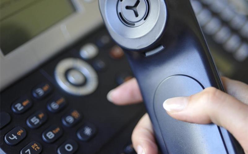 Eine Frau hält den Hörer eines Festnetz-Telefons in der Hand - der Apparat ist seit der Pandemie wieder im Kommen. Foto: Marc Müller/dpa