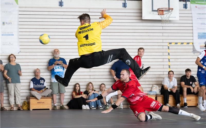 Einen großen Sprung macht in dieser Szene Mateusz Kornecki (HBW Balingen-Weilstetten), doch SG-Kreisläufer Nik Wittke (Nr. 54) bringt den Ball dennoch an ihm vorbei.