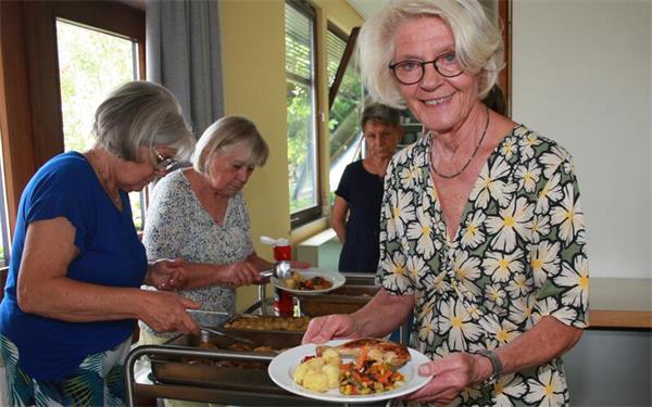 Es gibt Hühnchen. Das Team serviert den Hauptgang. GB-Foto: Diakonieverein Gäufelden