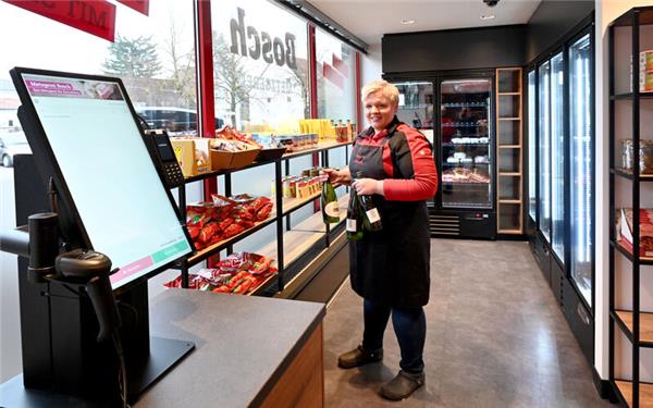 Fabienne Bosch bestückt die Regale im neuen SB-Bereich in Kuppingen. Vorne links ist die Kasse zu sehen, an der die Kunden ihre Waren selbst scannen und bezahlen können. GB-Foto: Holom