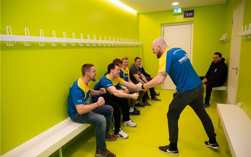 Gewöhnungsbedürftig: Im giftgrünen Ambiente der Umkleidekabine kann Marc Büchsenstein (stehend), Trainer der ersten Männermannschaft, sein Team künftig auf das bevorstehende Handballspiel einstimmen 