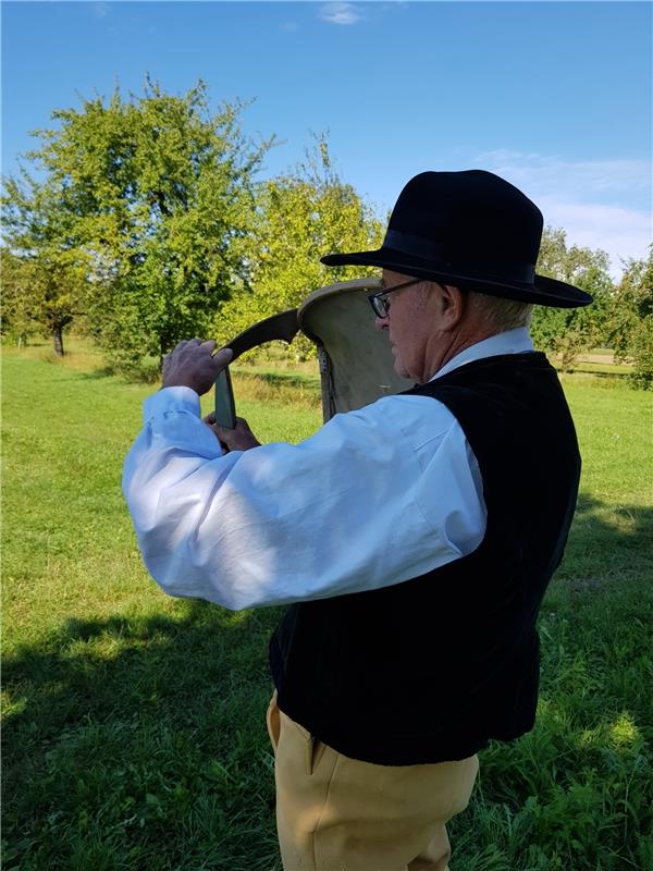 H. Widmayer in der Kuppinger Tracht weiß noch, wie es geht, mit der Sense mähen ...