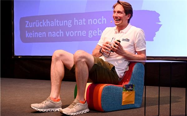 Hitschies-CEO Philip Hitschler-Becker erhält nach dem „DigiTalk“ einen Kindersessel, der in der Azubi-Werkstatt von Walter Knoll angefertigt wurde –extra im bunten Hitschies-Design mit einem Drachengesicht auf der Rückenlehne und Taschen an der Seite, um dort Bonbontütchen zu verstauen. GB-Foto: Holom