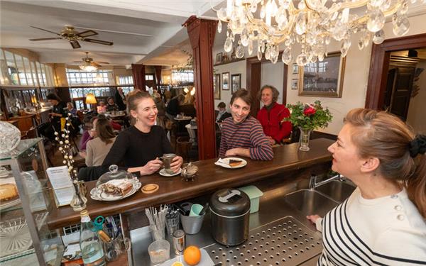 Im Café Là et Là: An der Theke (von links) Theresa Giese-Vogler, Willi Niethammer, hinten im roten Pulli Daniel Schürer und Hanna Vogler (rechts). Sie alle suchen nun Geschichten.GB-Foto: Vecsey