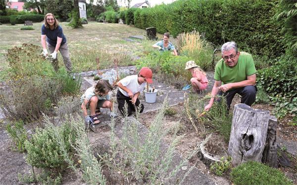 „Jeder Quadratmeter zählt“: Brigitte Kieser (von links), Anja Lamparter, Bernhard Müller sowie die Kinder Lotta, Fridolin und Ida gärtnern auf dem alten Friedhof in Gültstein.GB-Foto: Holom