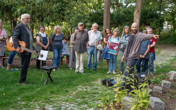 Johannes Kuhn (rechts) macht die Besucher auf ein Detail auf dem Tailfinger Friedhof aufmerksam. Seit 1982 wird dort am Antikriegstag der dort beerdigten Zwangsarbeiter gedacht. GB-Fotos: Vecsey
