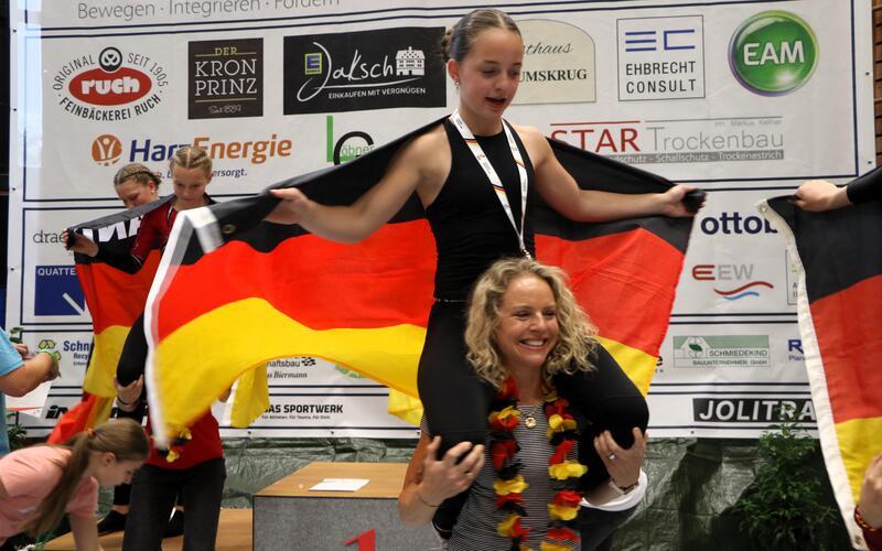 Kunstradfahren – Bei der Schüler-DM in Duderstadt konnte der hiesige Radsportbezirk zwei Titelgewinne feiern. So holte die für den RV Nufringen startende Kim Zarnetzki (auf den Schultern von Mutter Eva) mit neuer Bestleistung von 106,64 Punkten den deutschen Meistertitel vor Emmy Hoffmann (RSV Lieme/95,45). Hannes Altvater (Magstadt) triumphierte in der männlichen Konkurrenz, in der Joscha Harnisch (Nufringen) Zweiter wurde (ausführlicher Bericht folgt). gb/Foto: Schwarz