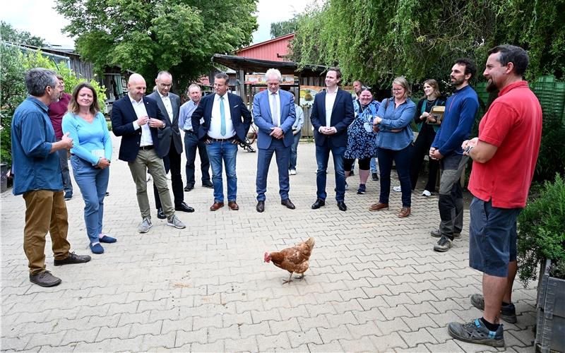 Landwirtschaft hautnah erlebt: Als die Gäste samt Bundeslandwirtschaftsminister Alois Rainer (Bildmitte) vor der Gärtnerei Station machten, spazierte ein Huhn vorbei und ließ sich auch von den hochrangigen Gästen nicht aus der Ruhe bringen. GB-Foto: Holom