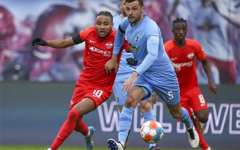 Leipzigs Christopher Nkunku (l) und Freiburgs Manuel Gulde im Duell. Foto: Jan Woitas/dpa-Zentralbild/dpa