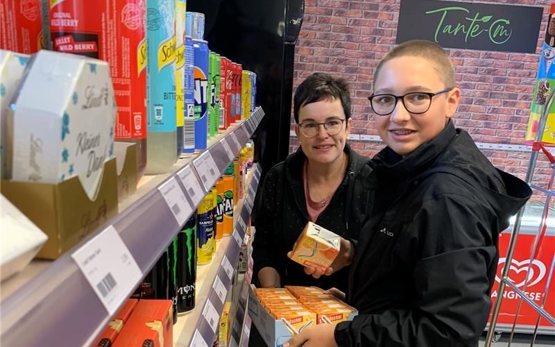 Margit Schermer und der 15-jährige Silas räumen Waren ein. GB-Foto: Holzapfel