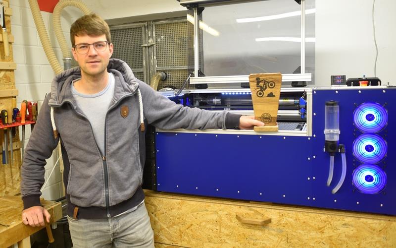 Mario Wolf in seiner Werkstatt – in der Hand hält er eine der von ihm gefertigten Trophäen. Rechts im Bild: einige seiner Prototypen. GB-Foto: Reichert