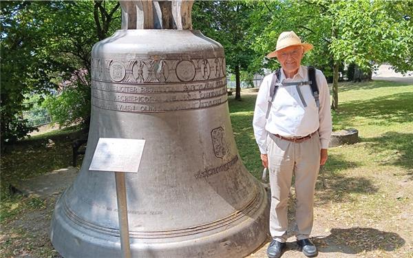 „Maxima f°“ steht seit 20 Jahren im Kirchgarten neben der Friedenslinde. Dieter Eisenhardt wirkt neben der gigantischen Glocke geradezu klein. GB-Foto: gb