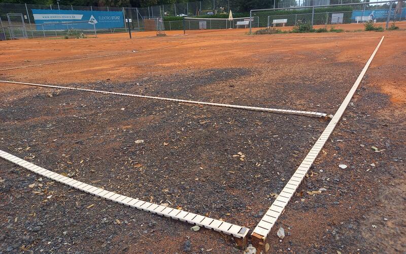 Mehr schwarz als rot: Das Lava-Naturgestein und Geröllsteine kommen auf Platz 3 der Bondorfer Tennisanlage deutlich zum Vorschein, auch die Verankerungen der weißen Tennislinien hat das jüngste Hochwasser freigelegt. GB-Fotos: gb