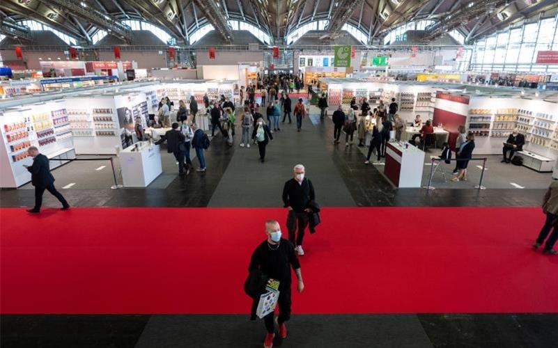 Menschen gehen während des ersten Besuchertags der Frankfurter Buchmesse 2021 durch die Halle 3.1. Foto: Sebastian Gollnow/dpa