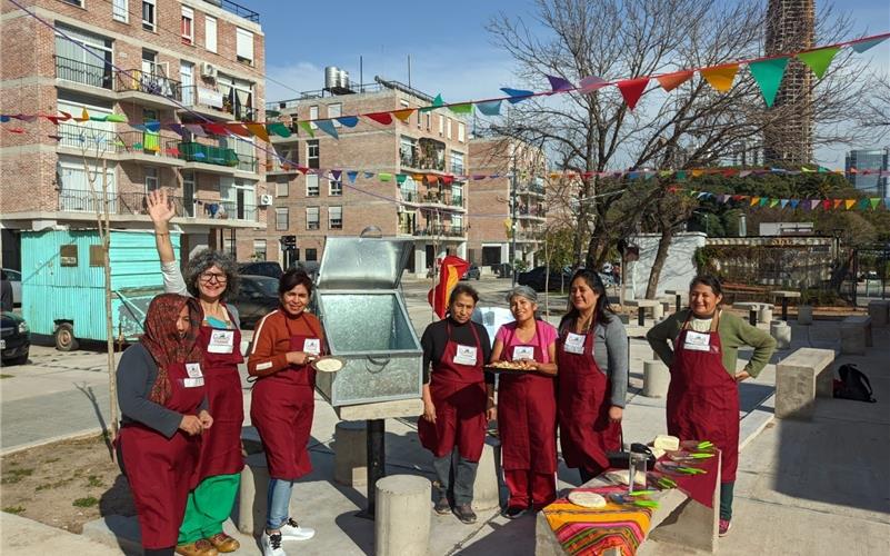 Mit einer vorläufigen Solar-Kochbox bereiten Kursteilnehmerinnen aus der Siedlung Villa LaMadrid, hier mit Andrea Vega (Zweite von links), Leiterin der Stiftung in Buenos Aires, Mahlzeiten zu. Im unteren Bild zu sehen ist der Parabolkocher. GB-Fotos: gb