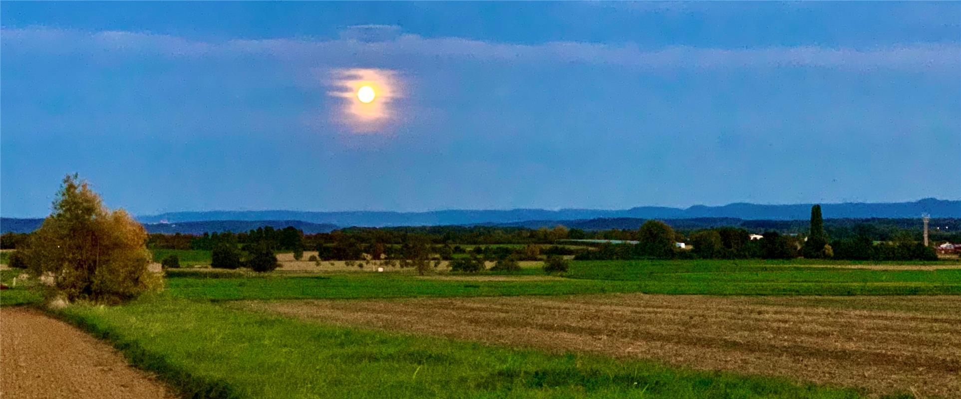 Mond mit rosa Halo über gäuschen Feldern. Von Minja Rollinson aus Gäufelden.