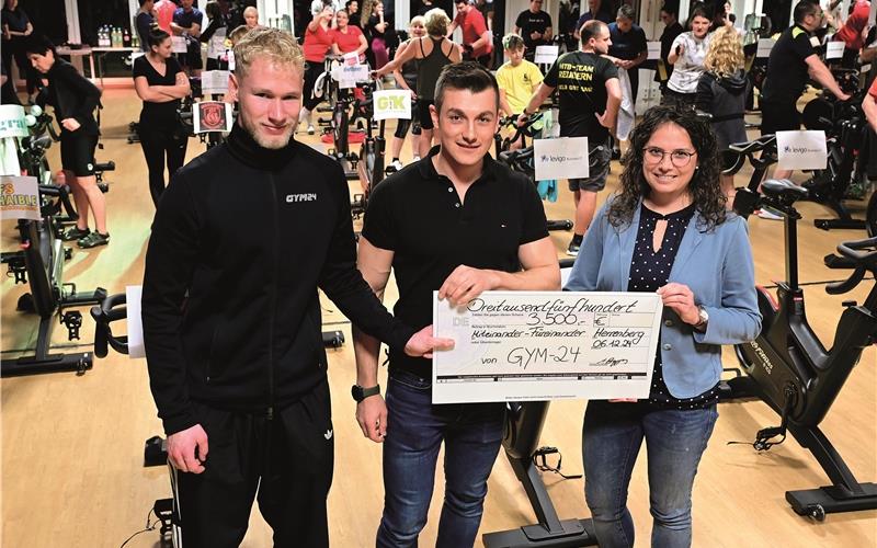 Nicolas Andres (links) und Adrian Beggers von Gym-24 übergaben den Scheck an Carolin Schlanderer für „Miteinander – Füreinander“.