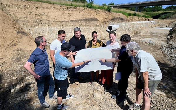 Ortstermin im Erzlochgraben mit Thomas Paul und Susanne Schreiber von der Stadt Herrenberg (beide in der Mitte): Im April war Baubeginn, die Fertigstellung des Hochwasserrückhaltebeckens soll im ersten Quartal 2027 erfolgen.GB-Foto: Holom