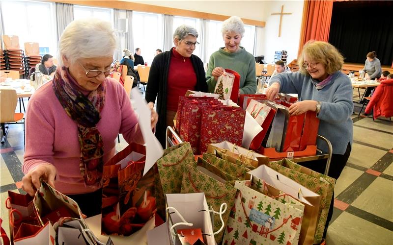 Auch kleine Päckchen helfen, Not zu lindern Packen Geschenke mit Einkaufsgutscheinen (von links): Ute Molls, Pfarrerin Friderike Schmalfuß (Sprecherin des Arbeitskreises „Miteinander – Füreinander“), Helga Dierich und Dr. Ulrike Altherr.GB-Foto: Holom