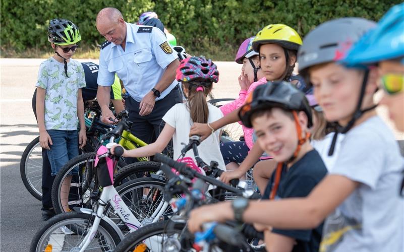 Polizist Detlef Langer kontrolliert die Fahrräder der teilnehmenden Kinder. GB-Foto: Vecsey