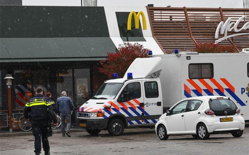 Polizisten ermittelt am Tatort, wo zwei Männer nach Schüssen in einem Schnellrestaurant ums Leben gekommen sind. Foto: Vincent Jannink/ANP/dpa