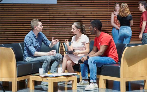 Prof. Dr. Christian Decker (links im Bild) im Gespräch mit Studierenden des Studiengangs Digital Business Engineering. GB-Foto