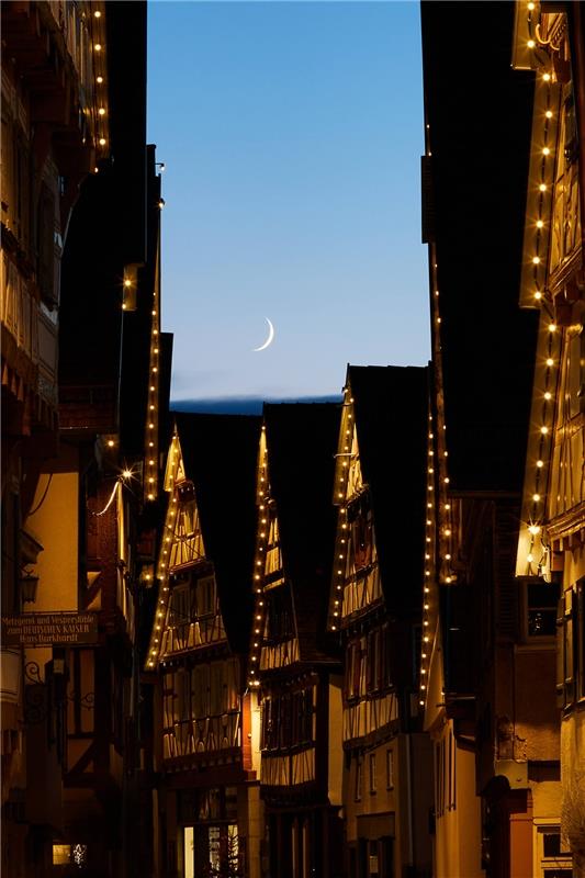Sichelmond über der weihnachtlich geschmückten Altstadt in Herrenberg. Dafür hat...