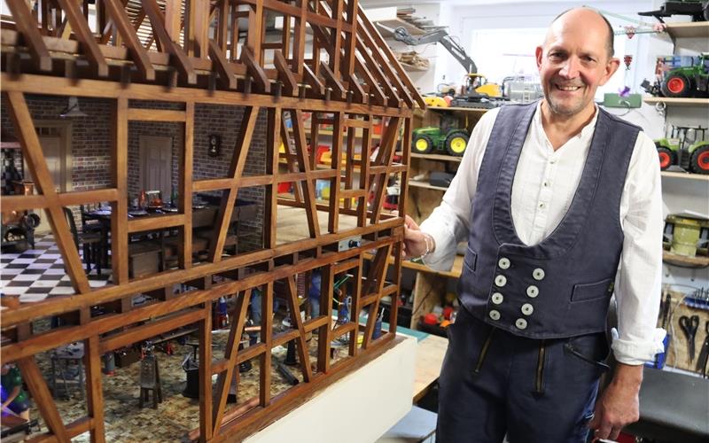 Stilecht in traditioneller Flaschner-Montur steht Rainer König in seiner Hobby-Werkstatt neben seinem Langzeitprojekt: Der gelernte Bauflaschner stattet ein maßstabsgetreues Fachwerkhausmodell mit detailverliebt bestückten Räumen und Werkstätten aus. Alle Teile und originalgetreue Werkzeuge fertigt der 62-Jährige selbst an – zur Not auf selbst gebauten Minimaschinen. GB-Fotos: Priotto